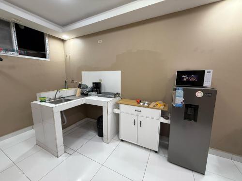 a small kitchen with a sink and a refrigerator at 10 minutos de UNAH Apartamento de 2 cuartos completo in Tegucigalpa