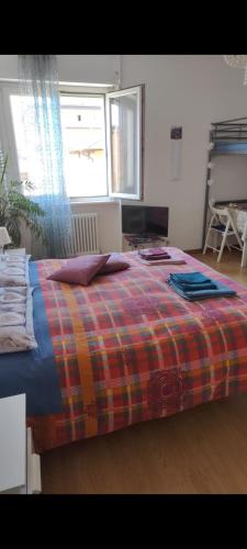 a bedroom with a bed with a plaid blanket on it at Bed and Breakfast Relax in Trento