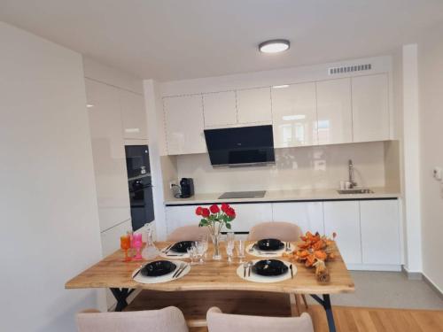 une cuisine avec une table en bois et des fleurs. dans l'établissement Appartement neuf et moderne à Puteaux, à Puteaux