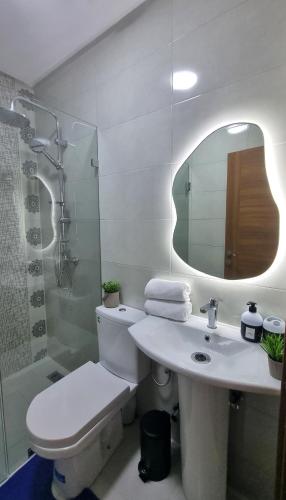 a bathroom with a toilet and a sink and a mirror at Cosy Stay 15min from Casablanca Airport, in Berrechid in Berrechid