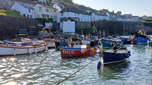 a group of boats are docked in a harbor at The Old Post Office in Coverack