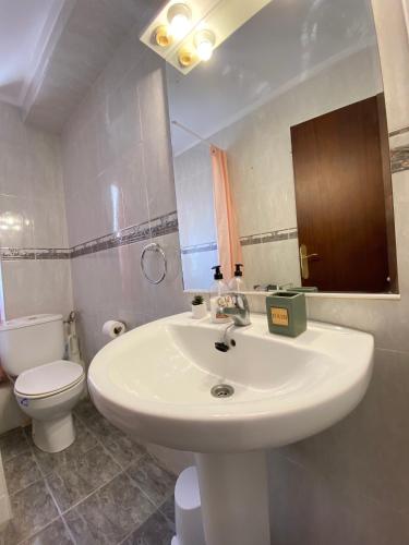 ein Badezimmer mit einem weißen Waschbecken und einer Toilette in der Unterkunft Balears Relax Apartment in Puerto de Gandía