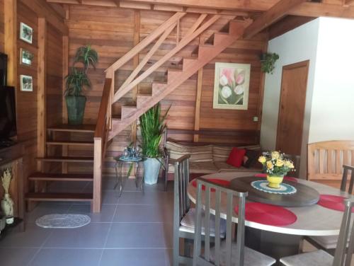 a living room with a staircase and a table and chairs at Paraíso das montanhas in São Bonifácio