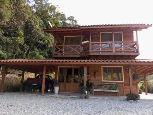 a large wooden house with a porch at Paraíso das montanhas in São Bonifácio