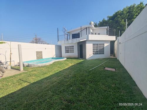 a white house with a swimming pool in a yard at Casa Frida Yautepec Morelos in Yautepec