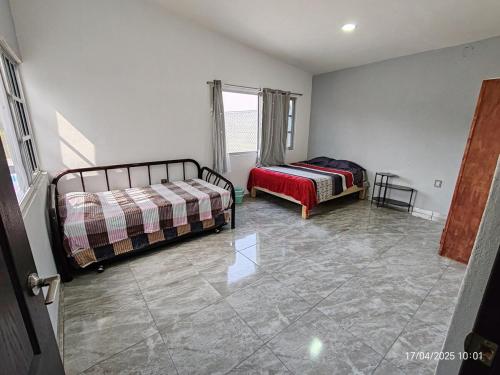 a bedroom with two beds and a couch in it at Casa Frida Yautepec Morelos in Yautepec
