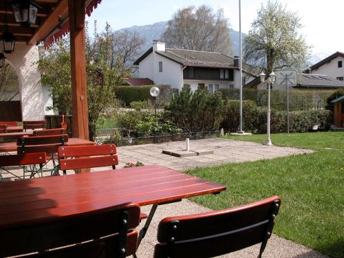 a picnic table and chairs in a park with a field at Hotel-Restaurant Zum Hirschhaus Inklusiv Chiemgaukarte in Ruhpolding