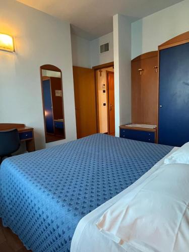 a bedroom with a large bed with a blue blanket at Hotel La Terrazza in Porto San Giorgio