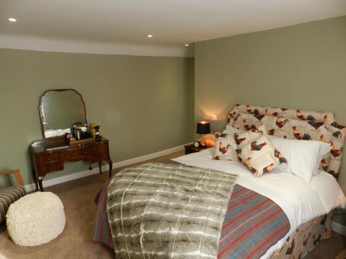a bedroom with a bed and a table with a mirror at White Swan Inn in Belford