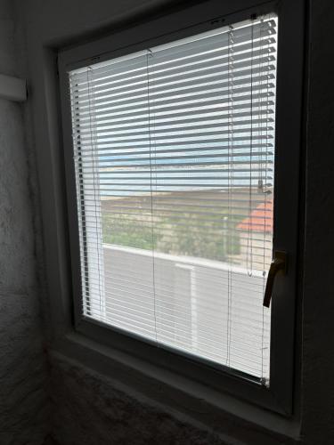 a window with the blinds on it with a view at Vila Kula in Nin