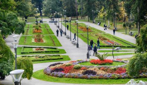 people walking in a park with flowers and lights at Apartmani Martenovic 1 in Vrnjačka Banja