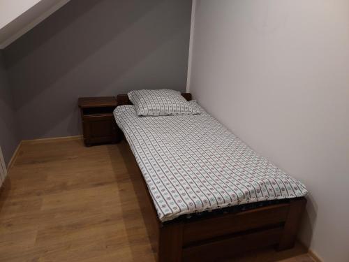 a small bed in a corner of a room at Apartament na Górce in Mikołajki