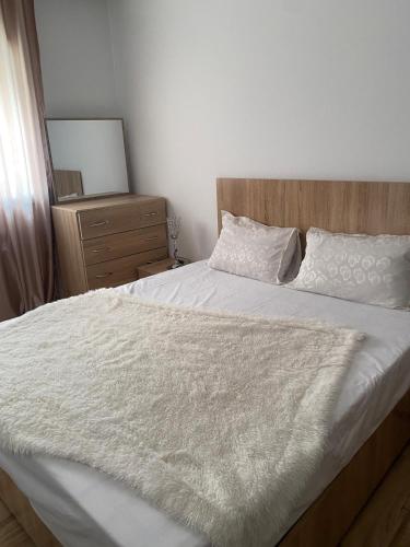 a bedroom with a white bed with a wooden headboard at Appartement de standing à EZZAHRA in Ez Zahra