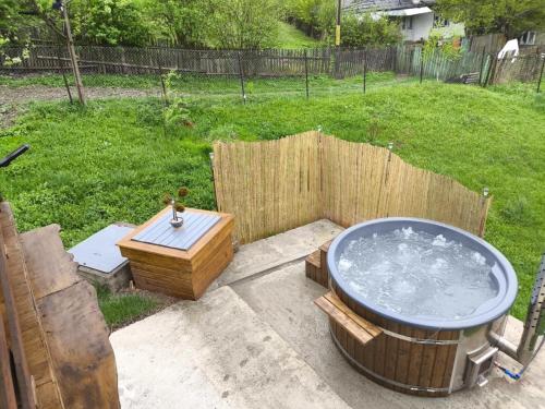a hot tub in a yard with a wooden fence at Cabana de lemn Lacul Bicaz in Hangul