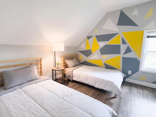 a bedroom with two beds and a geometric wall at 5Guest House Baltimore County(own room, Joppa RD) in Parkville