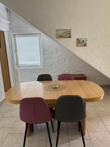 a wooden table with four chairs in a room at Vila Kula in Nin