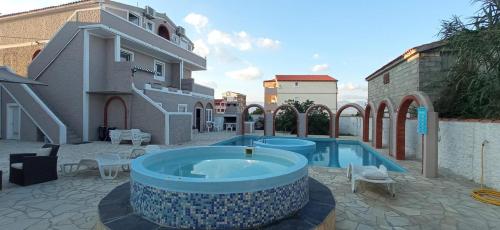 a large swimming pool in a courtyard next to a building at Vila Kula in Nin