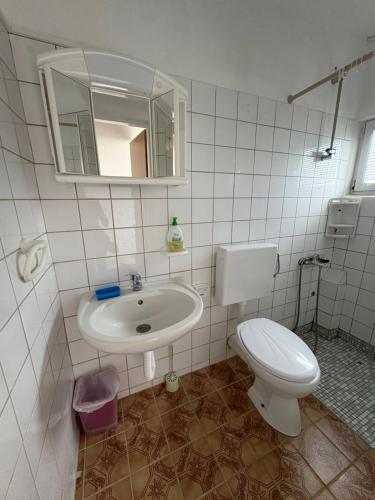 a bathroom with a sink and a toilet and a mirror at Vila Kula in Nin