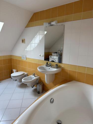 a bathroom with three sinks and a bath tub at Chalupa - Vinařství Popela in Perná
