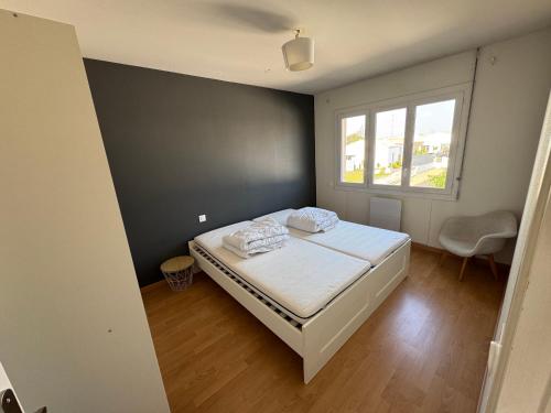 une petite chambre avec un lit et une fenêtre dans l'établissement Logement 6 couchages, 3 chambres , jardin , parking , fibre wifi, à Les Sables-dʼOlonne
