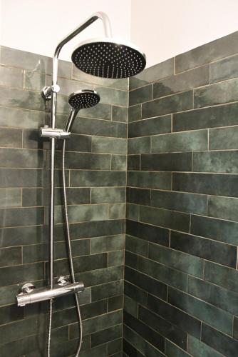 La salle de bains est pourvue d'une douche avec du carrelage vert du métro. dans l'établissement Appartement pour 7 personnes dans une maison du XVIIIème siècle à Livinhac-Le-Haut, à Livinhac-le-Haut