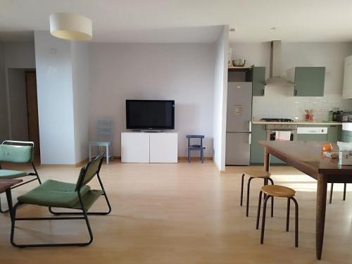un salon avec une table et des chaises et une cuisine dans l'établissement Appartement pour 7 personnes dans une maison du XVIIIème siècle à Livinhac-Le-Haut, à Livinhac-le-Haut