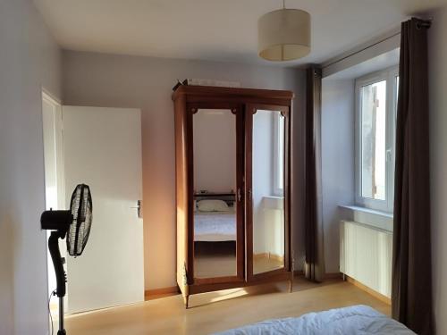 - un miroir dans une chambre avec un lit et une fenêtre dans l'établissement Appartement pour 7 personnes dans une maison du XVIIIème siècle à Livinhac-Le-Haut, à Livinhac-le-Haut