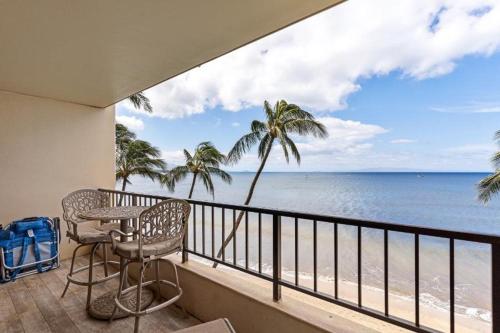 a balcony with a table and chairs and the ocean at Sugar Beach Resort, #524 in Kihei