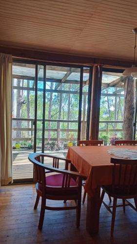 a dining room with a table and chairs and windows at Habitaciones en Playa La Sirena in La Viñuela