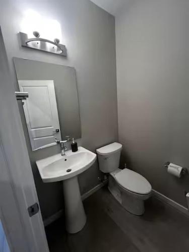 a white bathroom with a toilet and a sink at Brand New Bedroom with private bathroom in Keswick in Edmonton