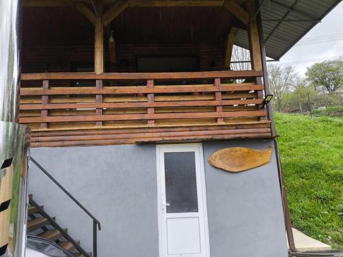 a dog house with a porch and a door at Cabana de lemn Lacul Bicaz in Hangul