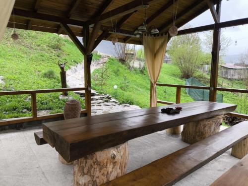 a large wooden table on a patio with a view at Cabana de lemn Lacul Bicaz in Hangul