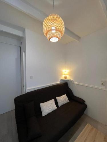 - un canapé noir dans le salon lumineux dans l'établissement T2 cozy en centre-ville, à Montélimar