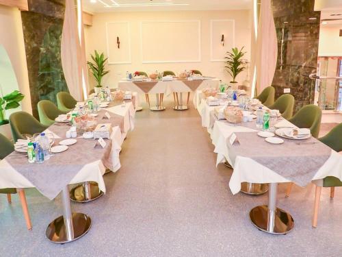 a row of tables in a room with white table settings at Paradise Home City Stars in Cairo