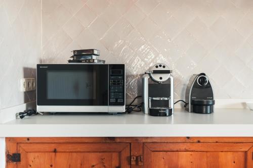 a microwave and a coffee maker on a counter at Traumhafte Finca auf Mallorca mit Pool 1A Lage direkt am Meer bei Es Trenc Bootstouren auf Anfrage möglich in Sa Ràpita