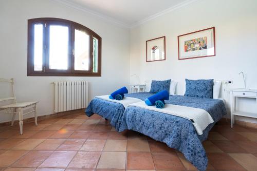 a bedroom with two beds with blue pillows at Traumhafte Finca auf Mallorca mit Pool 1A Lage direkt am Meer bei Es Trenc Bootstouren auf Anfrage möglich in Sa Ràpita