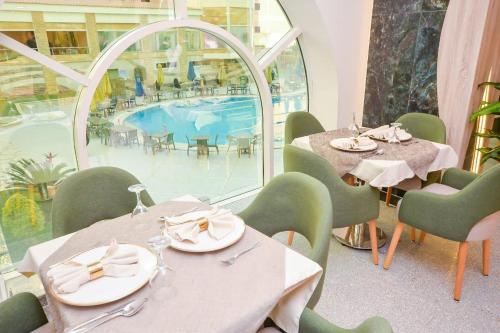 a restaurant with tables and chairs and a pool at Paradise Home City Stars in Cairo