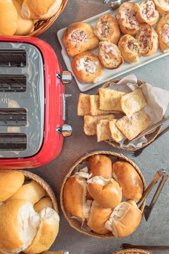 einen Tisch mit Körben mit Brot und Gebäck in der Unterkunft Suítes 91 in Penha
