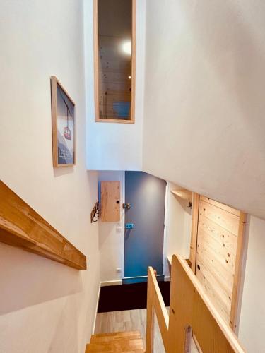 un escalier dans une maison aux murs bleus dans l'établissement Appartement Les Arcs 1800 - Charmettoger, à Bourg-Saint-Maurice