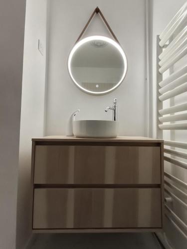 une salle de bain avec un lavabo et un miroir au mur dans l'établissement Appartement cosy Nantes proche gare, à Nantes