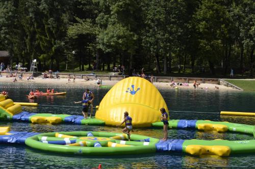 a group of people in a pool with inflatables in the water at Charmant Bungalow, lac bleu Morillons - Verchaix in Verchaix