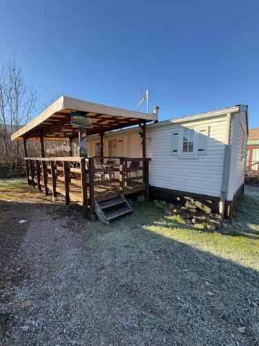 a house with a porch and a wooden fence at Charmant Bungalow, lac bleu Morillons - Verchaix in Verchaix