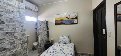 a small bathroom with a bed and a tile wall at Casa Altamira in San Pedro Sula
