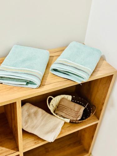 a wooden shelf with towels and a basket on it at Sweet Home in Kosovo Polje