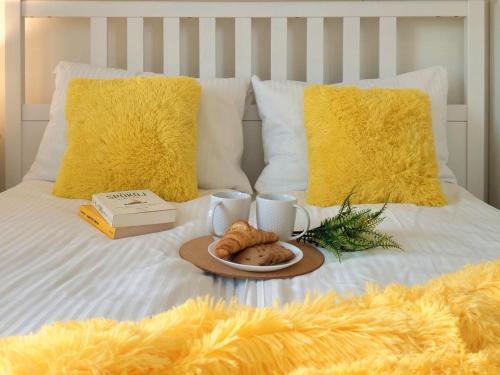 a tray of food on a bed with yellow pillows at Apartament z Widokiem na Rynek w Żywcu in Żywiec