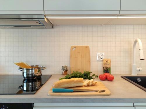 a kitchen counter with a cutting board and vegetables at Apartament z Widokiem na Rynek w Żywcu in Żywiec