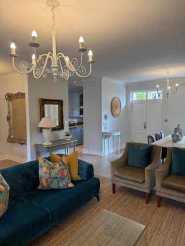 een woonkamer met een blauwe bank en een tafel bij Franschoek Lermitage Villa 33 Three Bedroom Lake View in Franschhoek