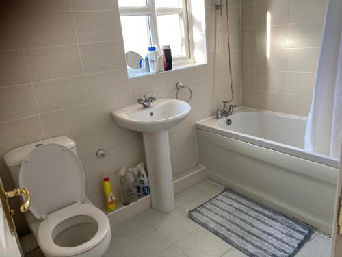 a bathroom with a toilet and a sink and a bath tub at InMind in Peterborough