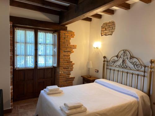 a bedroom with a bed with towels on it at Apartamentos Villa Julieta in Ruente