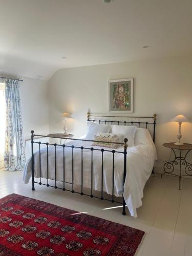 a bed in a bedroom with two lamps and a rug at Drummin Cottage in Tinahely